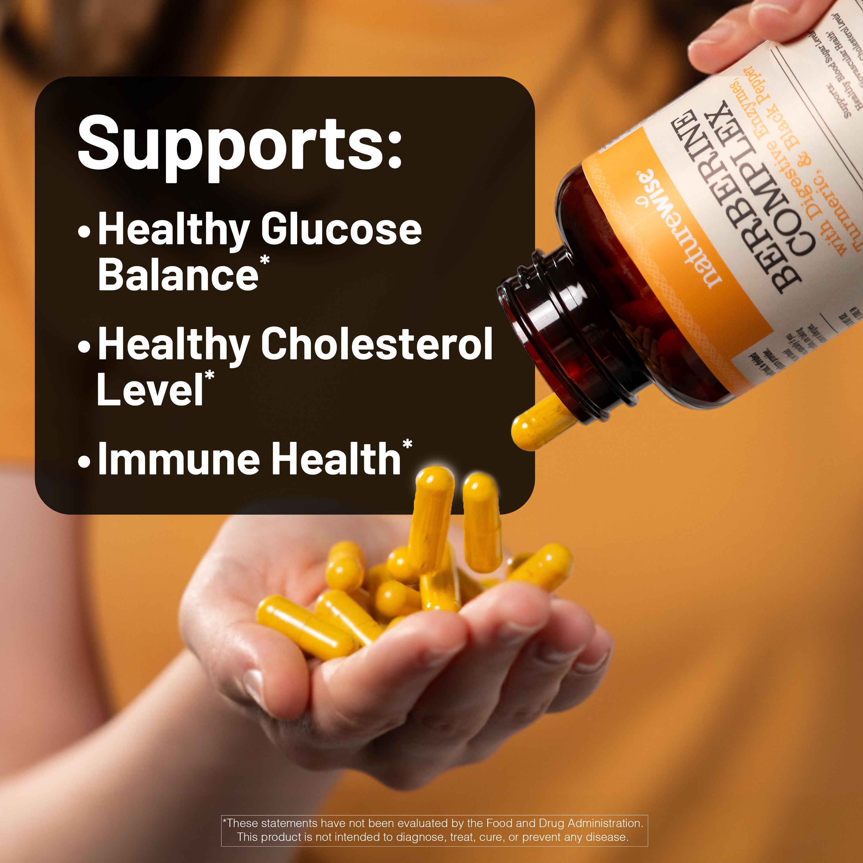 Hand holding yellow capsules with a bottle of supplements labeled Berberine Complex against an orange background.