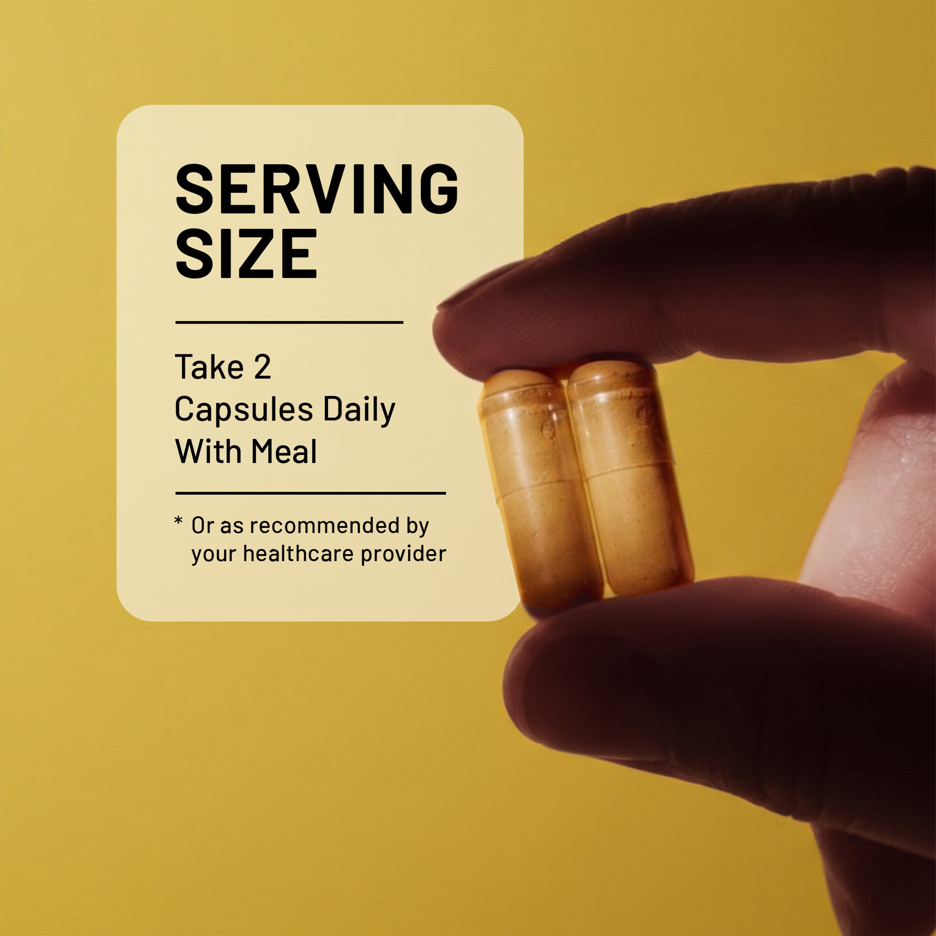 Hand holding two NatureWise Organic Ginger capsules with text about the suggested serving size on a yellow background