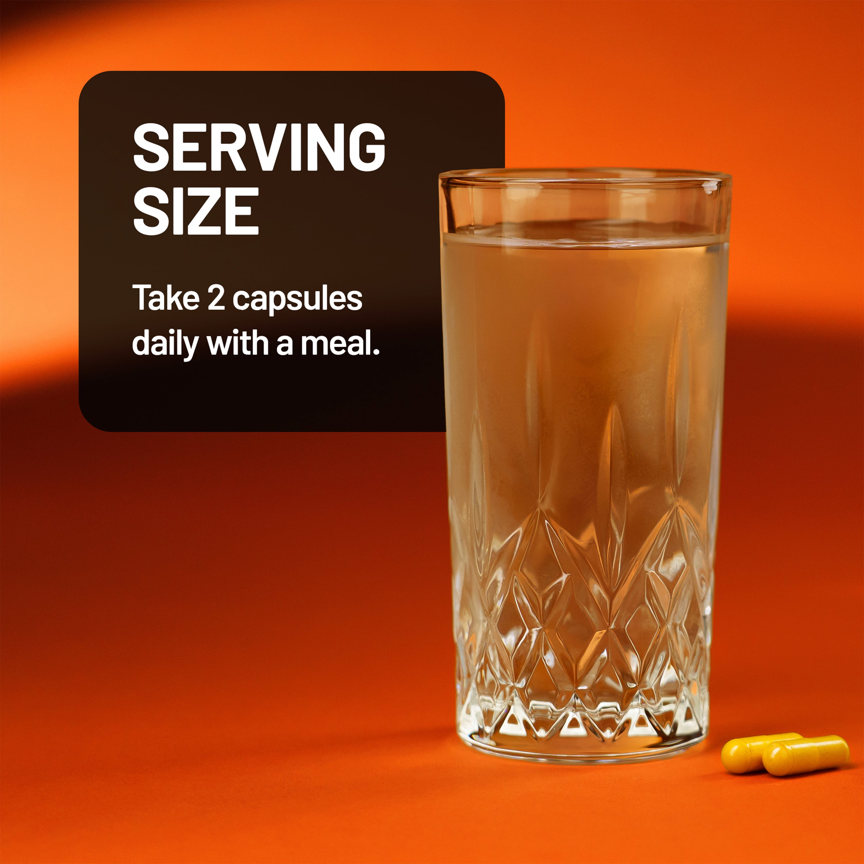 Glass of liquid with a serving size label and capsules on an orange background