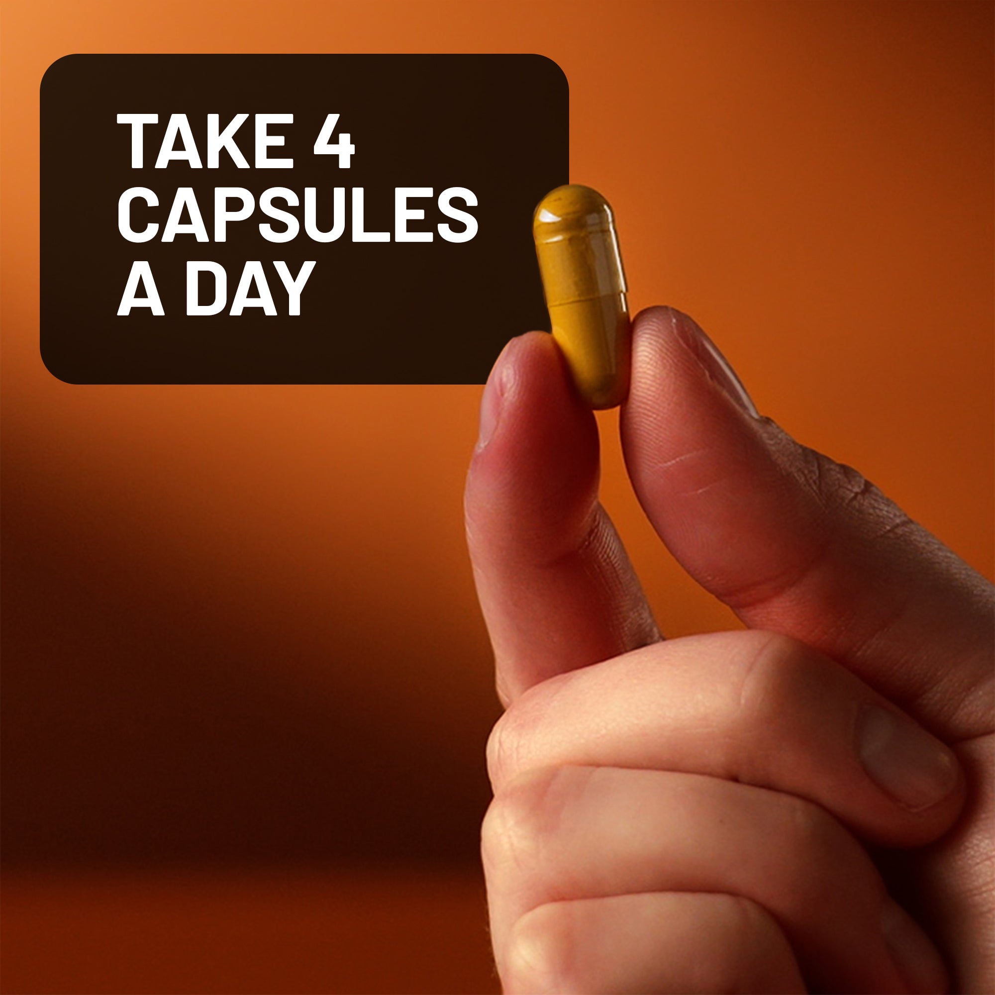 Hand holding a capsule with text 'Take 4 Capsules A Day' on an orange background