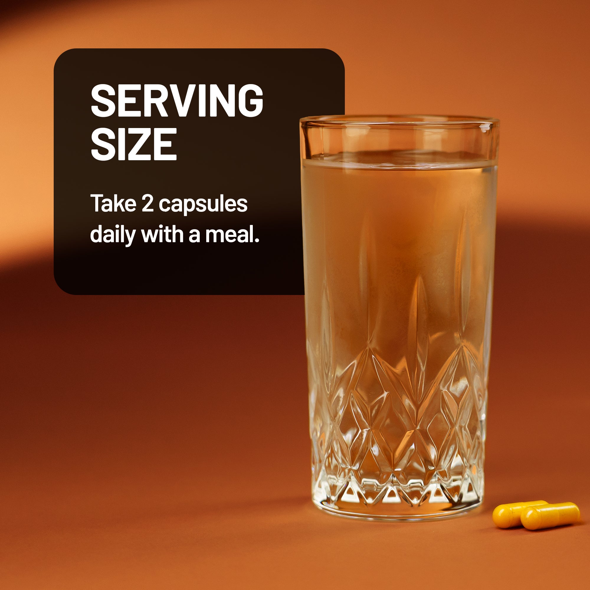 Glass of liquid with a serving size label and capsules on an orange background