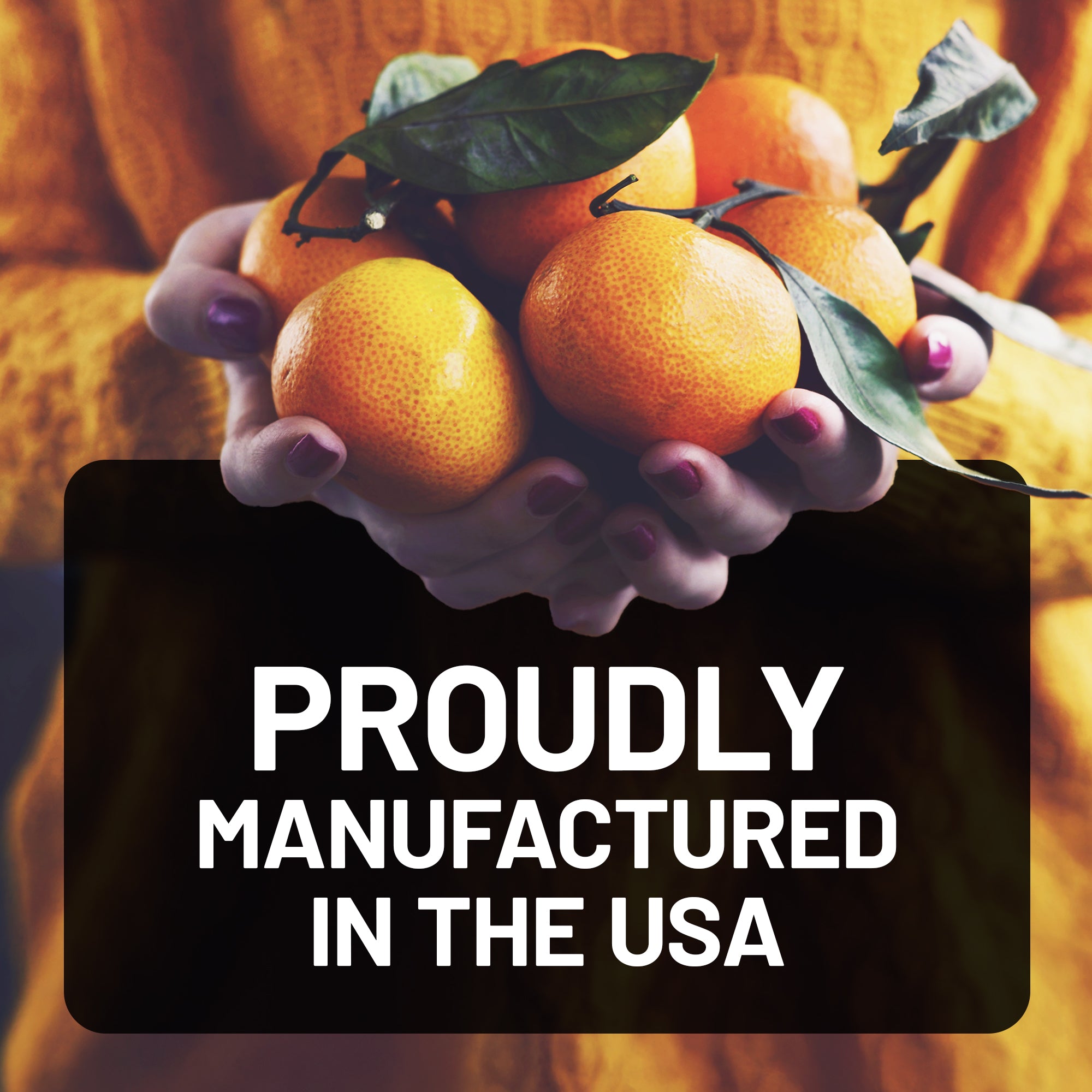 Person holding oranges with text 'Proudly Manufactured in the USA' on a blurred background