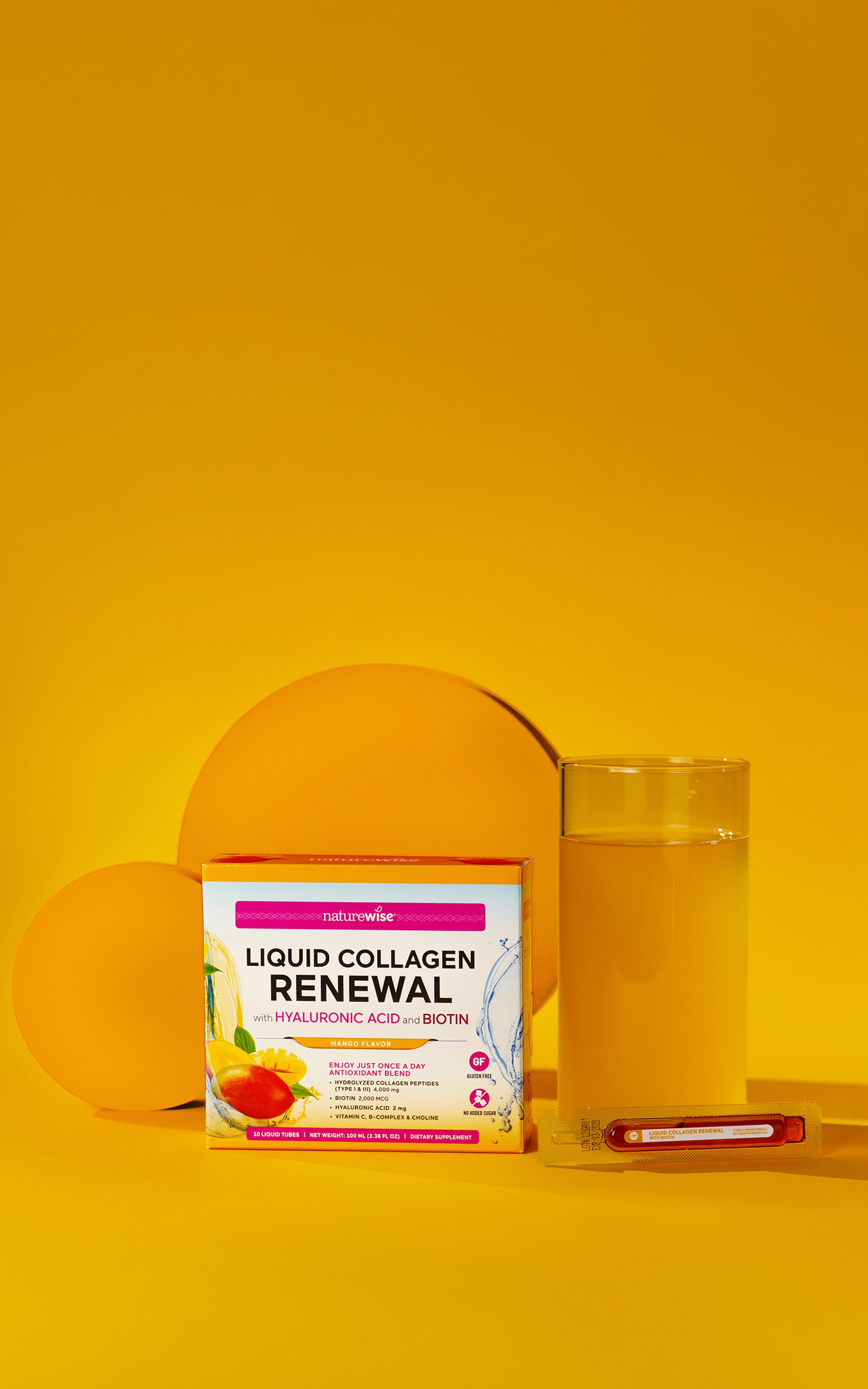 Box of NatureWise 'Liquid Collagen Renewal' supplement with hyaluronic acid and biotin in mango flavor on a yellow background with a glass of liquid collagen mango.