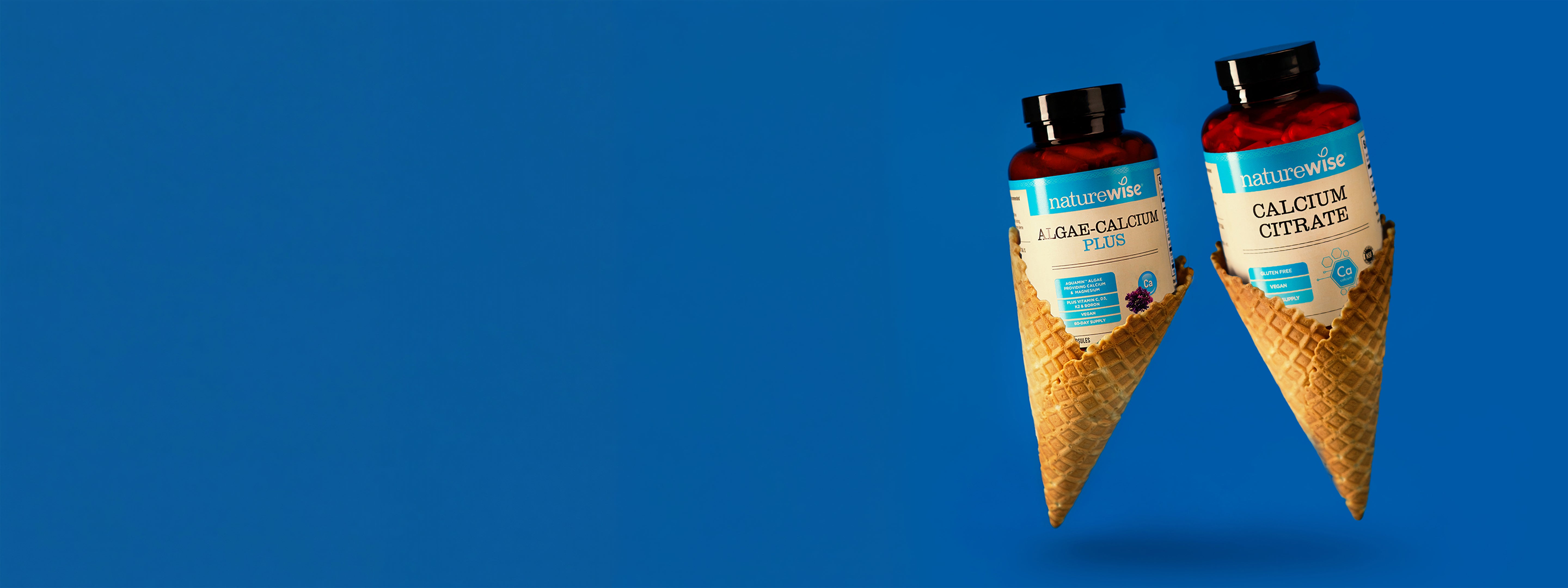 Two bottles of NatureWise calcium supplements in an ice cream cone packaging on a blue background