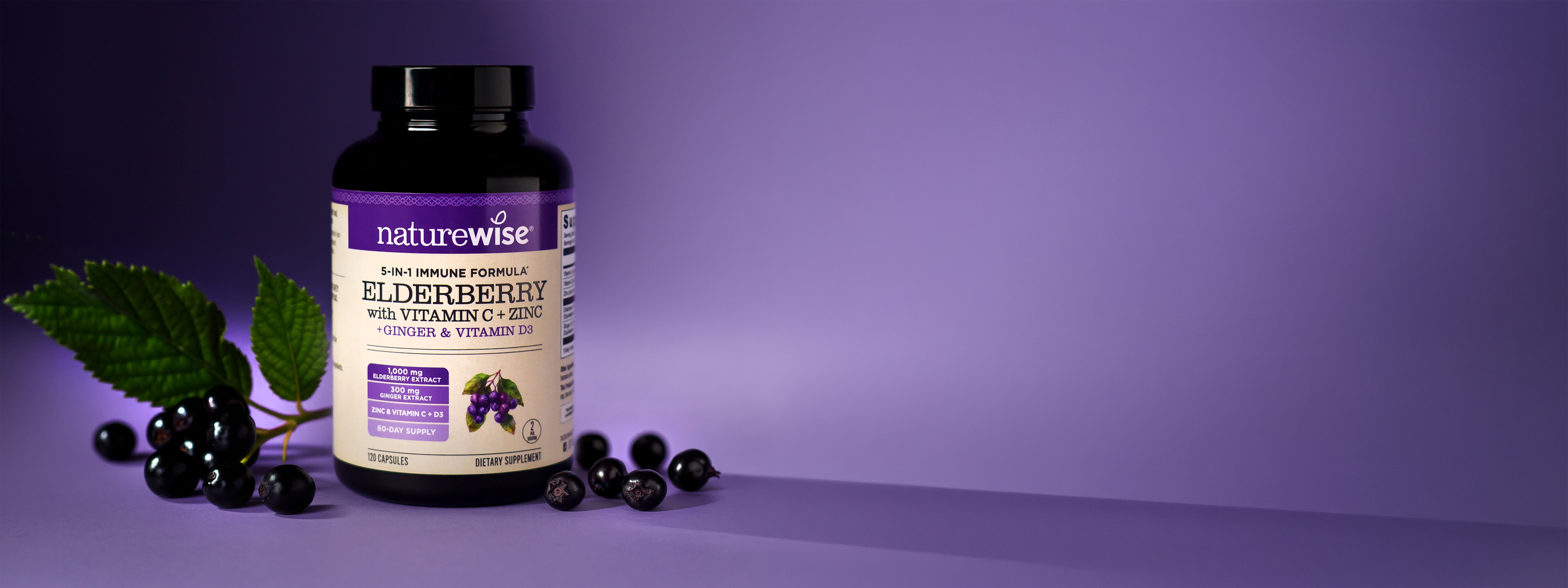 NatureWise Elderberry with Vitamin C, Zinc, Ginger, and Vitamin D3 supplement bottle with black elderberries on a purple background