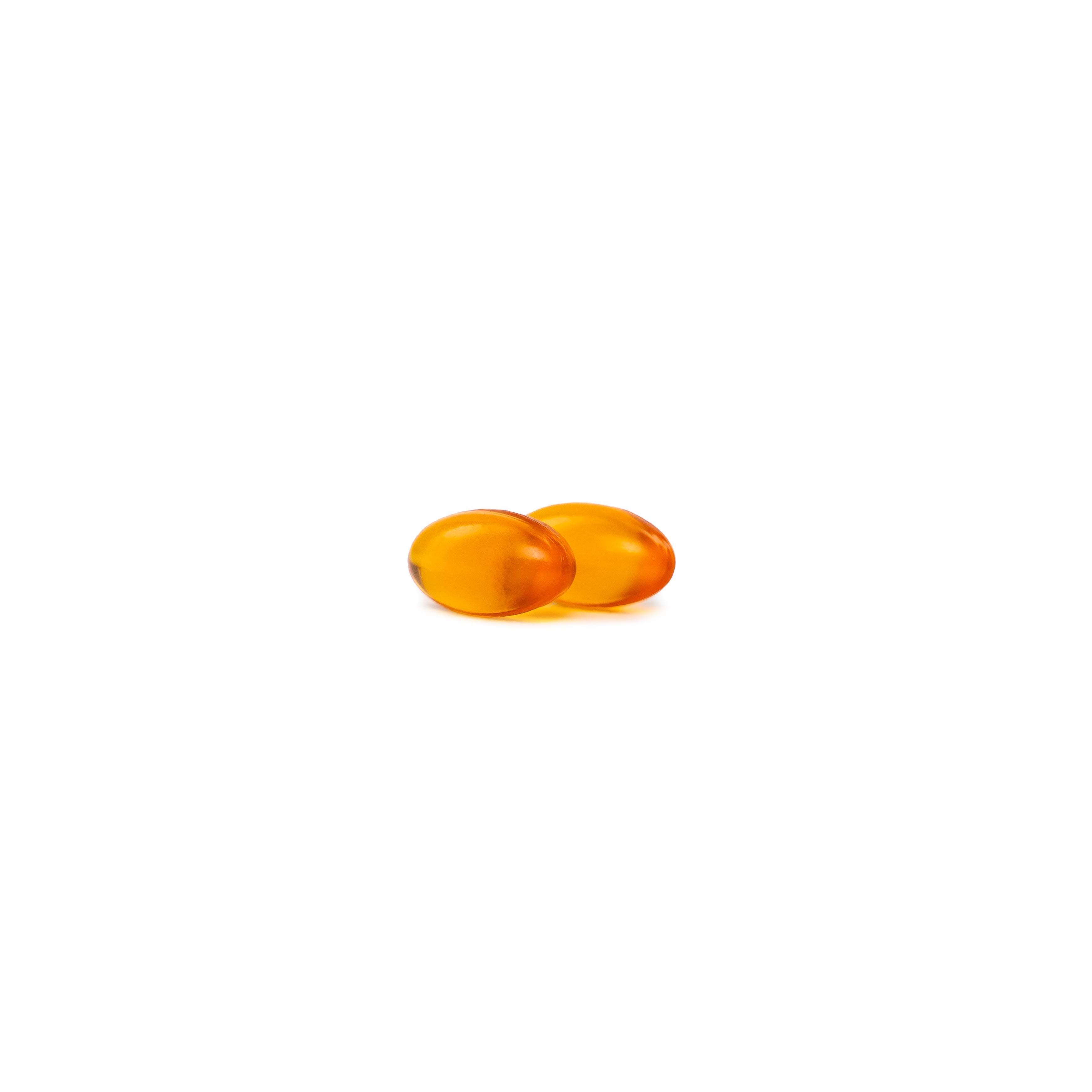 Two Gold Oil of Oregano softgel on a white background
