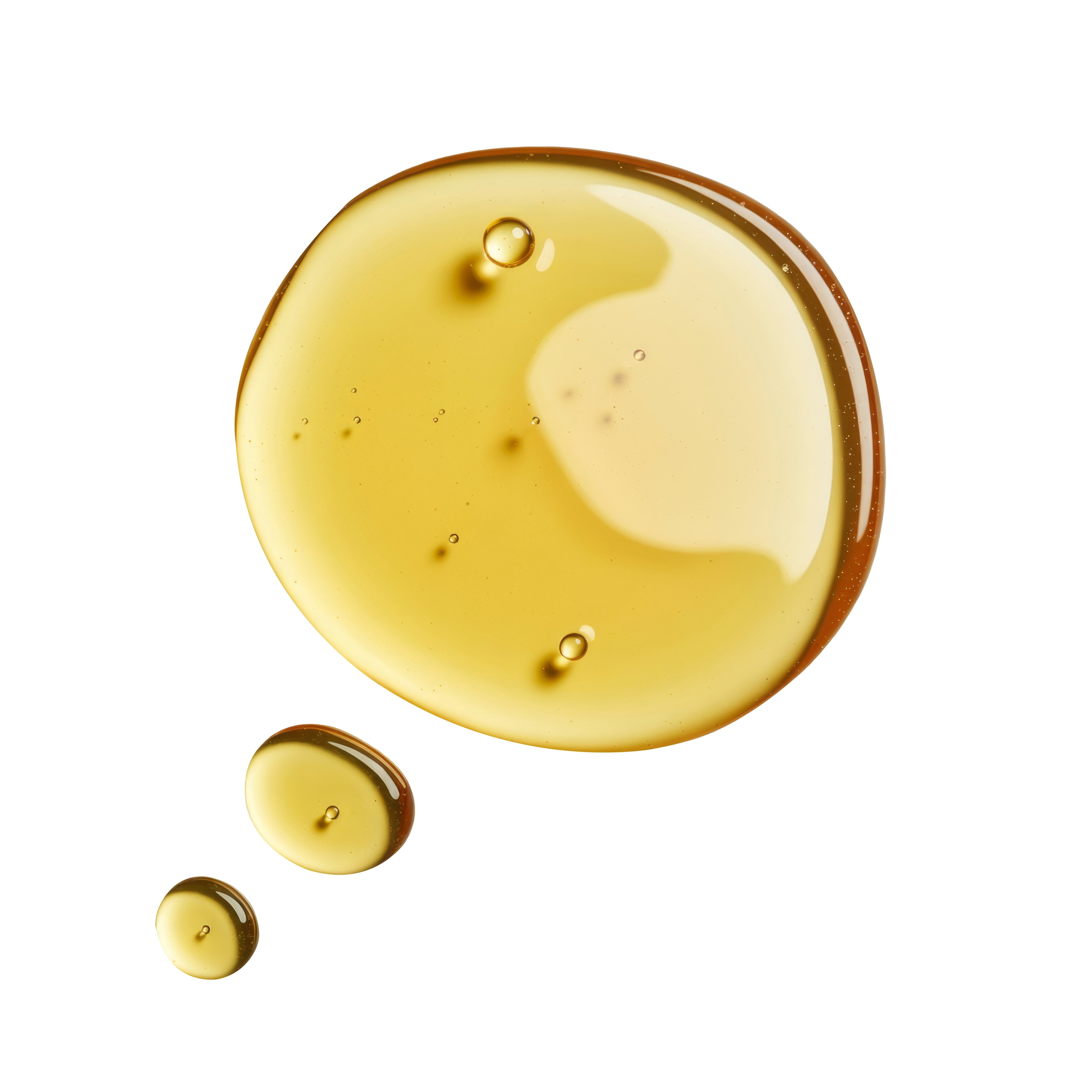 Close-up of amber-colored tocopherol oil droplets on a white background