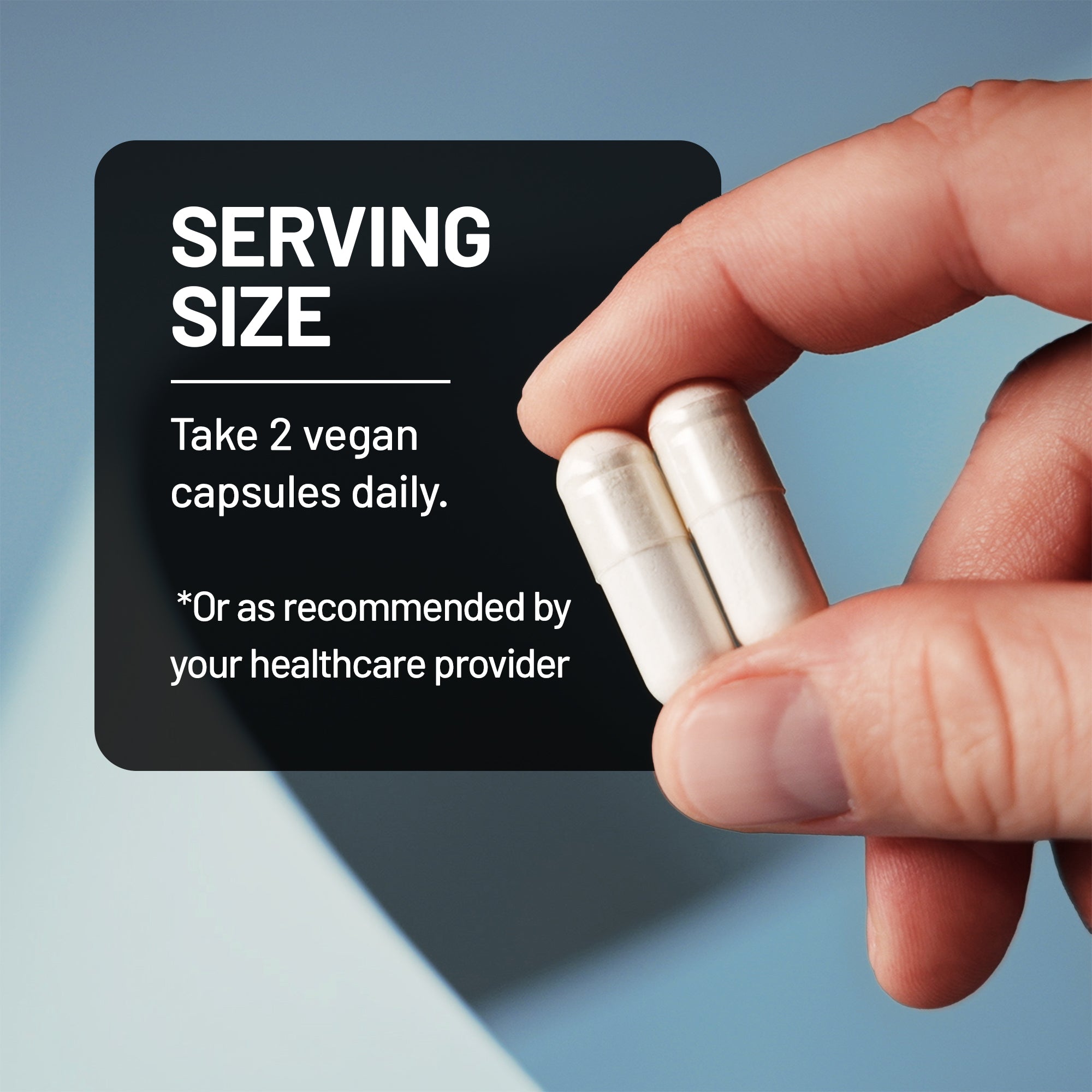 Hand holding up two white capsules of NatureWise Magnesium Complex with 7 active magnesium types with text indicating it's serving size.