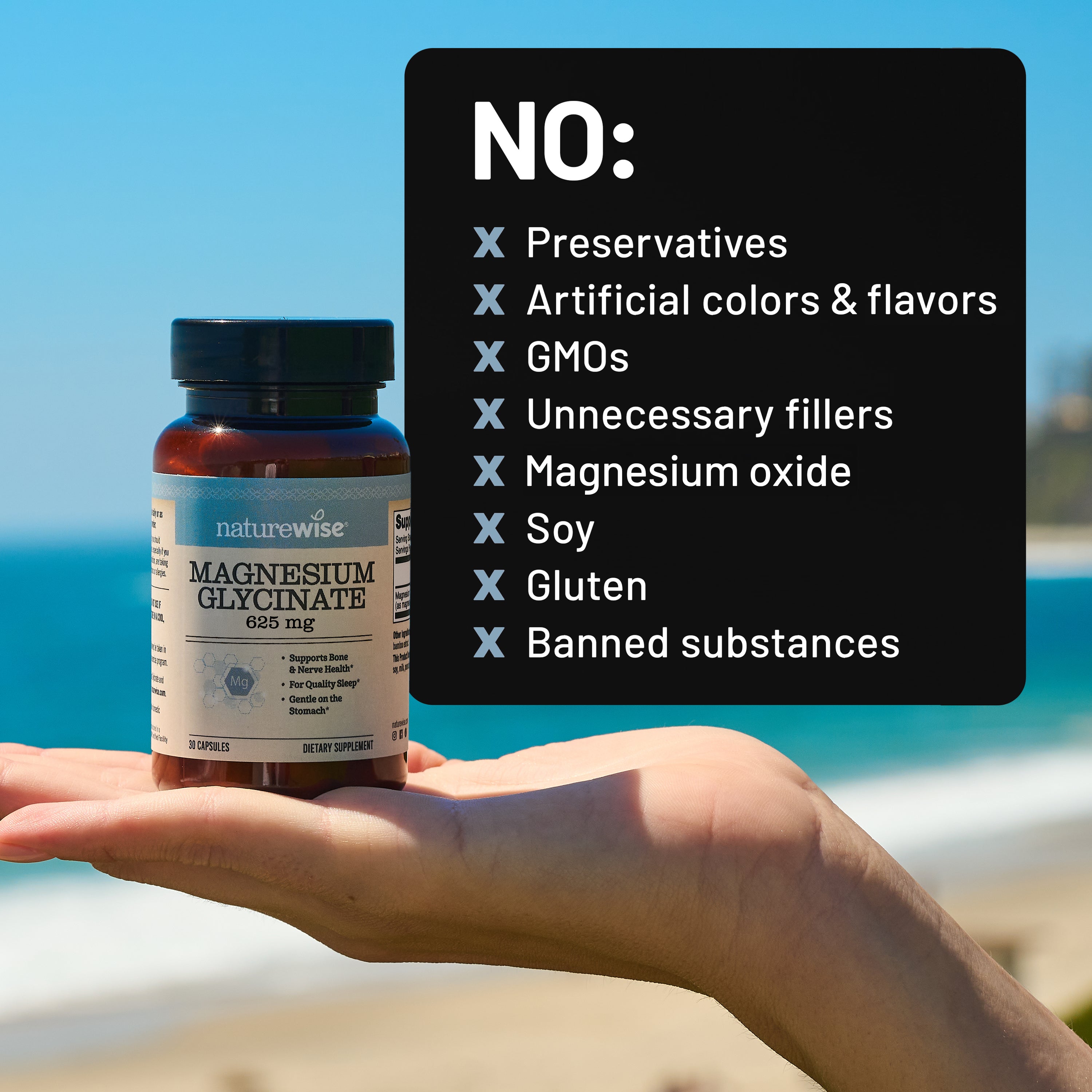 Hand holding a bottle of Naturewise Magnesium Glycinate supplement with a list of 'No' items on a beach background.