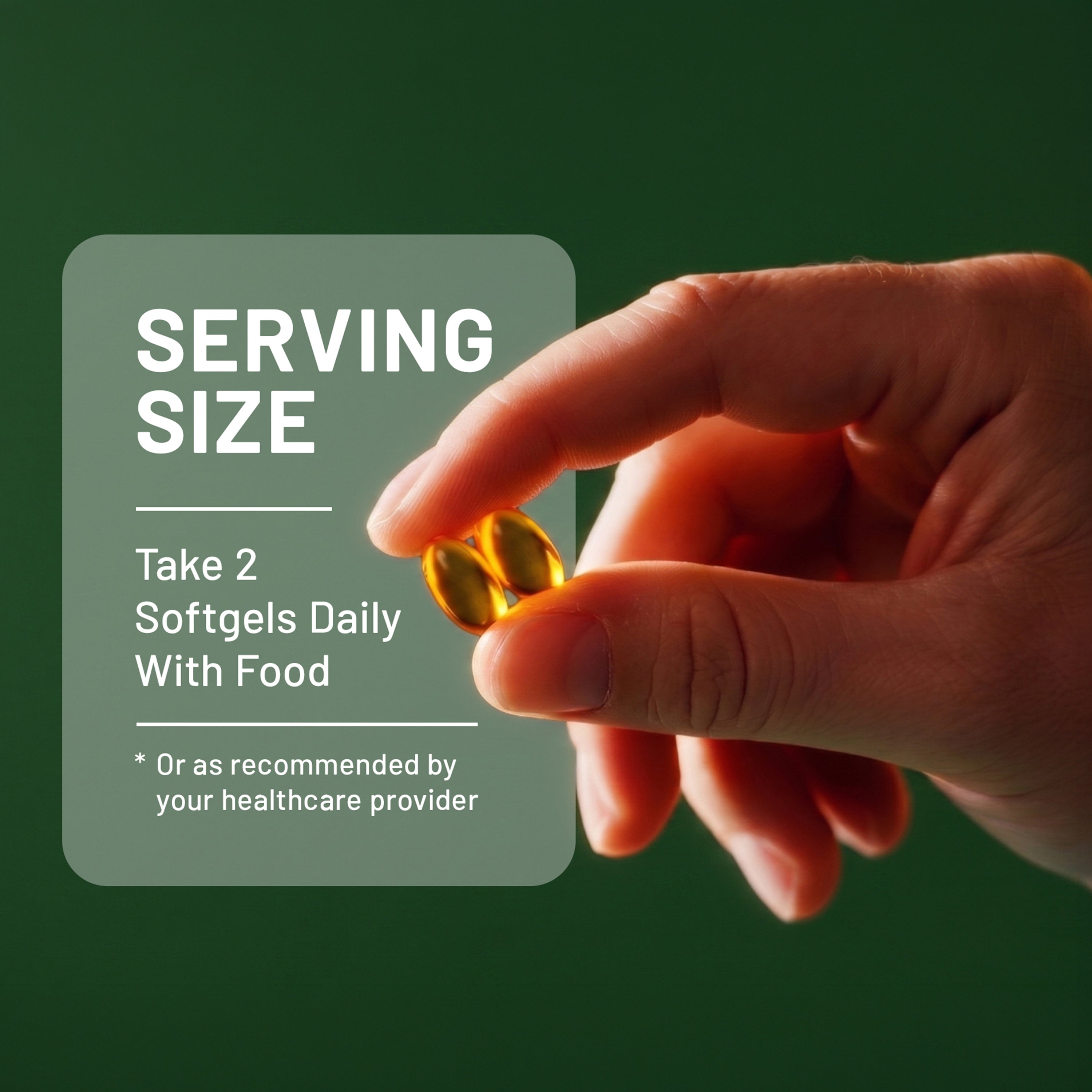 A close-up photograph of a hand holding two translucent, golden-yellow softgel capsules against a dark green background. A grey text box on the left reads "SERVING SIZE Take 2 Softgels Daily With Food."