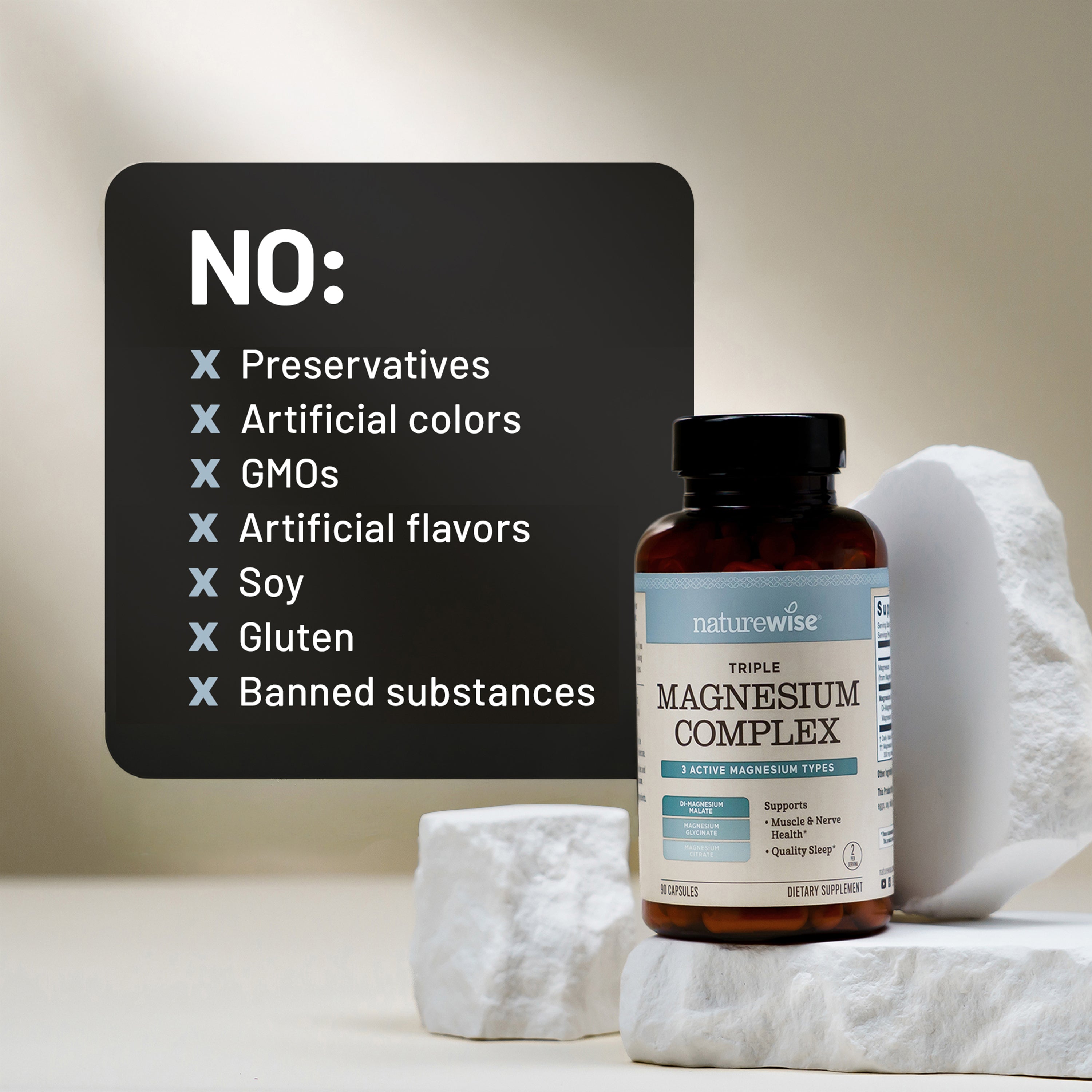 A bottle of NatureWise Triple Magnesium Complex supplement displayed on white decorative stones next to a black informational graphic listing excluded ingredients like preservatives, GMOs, and artificial flavors.