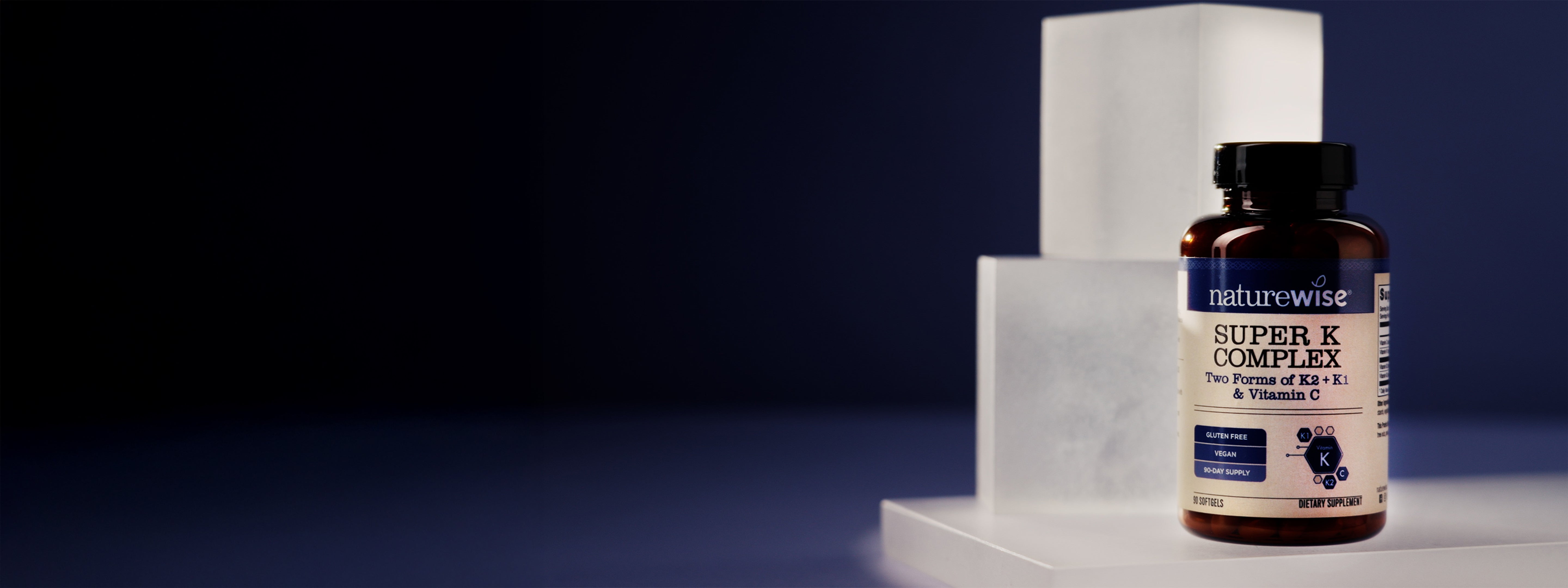 Naturewise Super K Complex supplement bottle on a white platform with a dark background