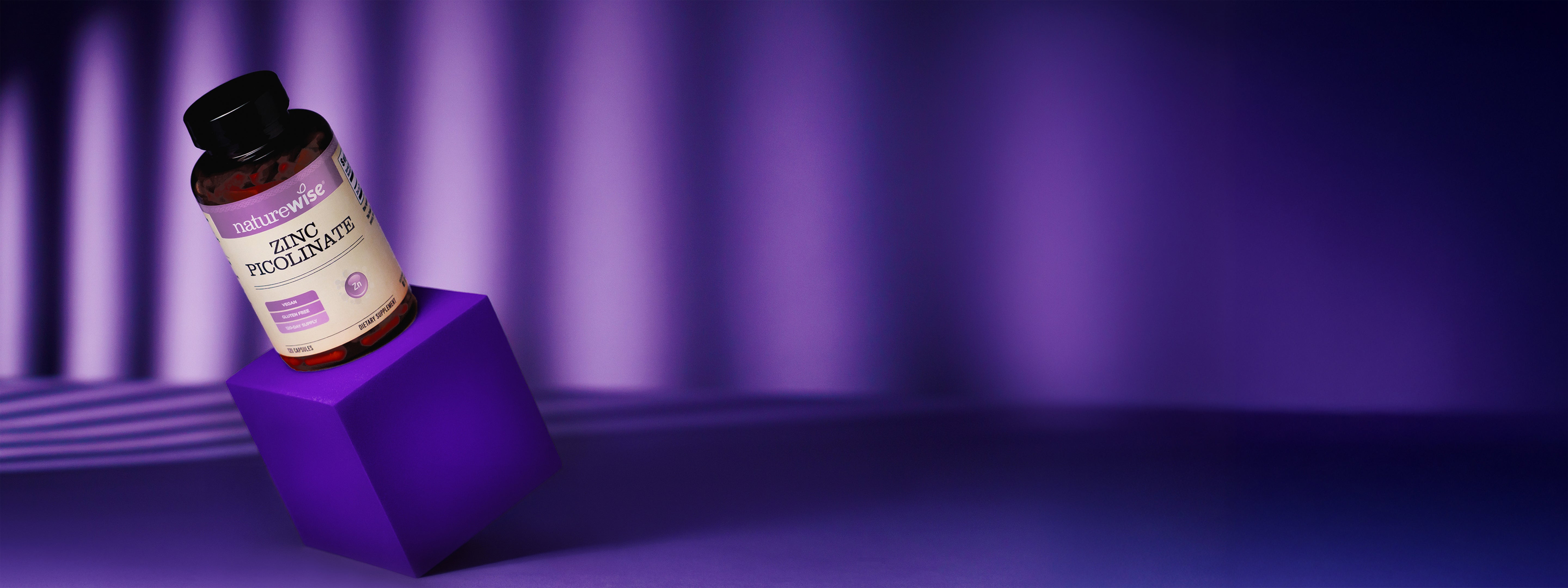 Bottle of Zinc supplement on a purple cube with a purple background