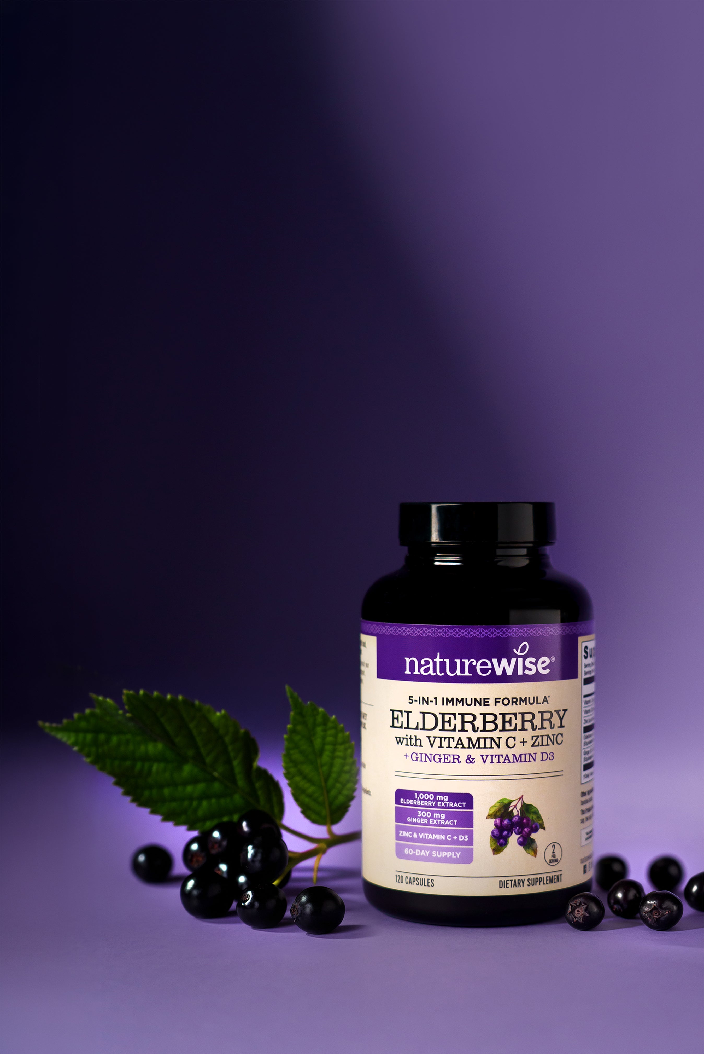 NatureWise Elderberry with Vitamin C, Zinc, Ginger, and Vitamin D3 supplement bottle with black elderberries on a purple background