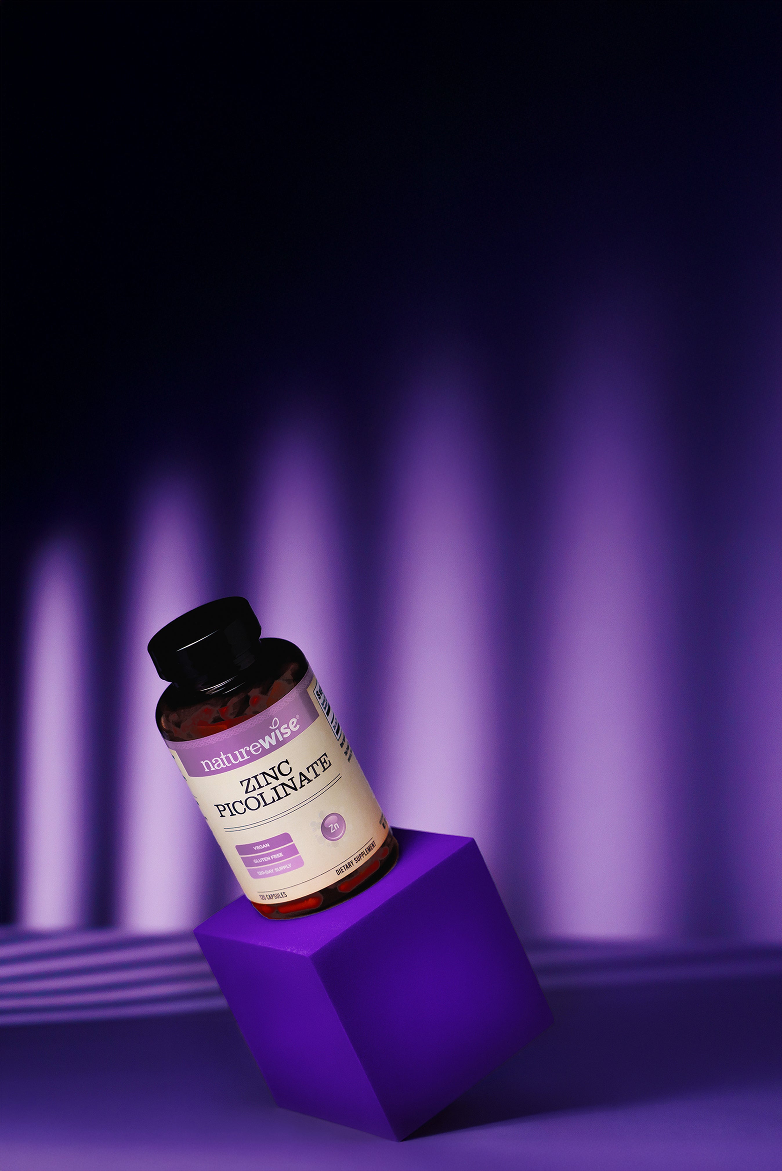 Bottle of NatureVia Zinc Picolinate on a purple stand with a dark background