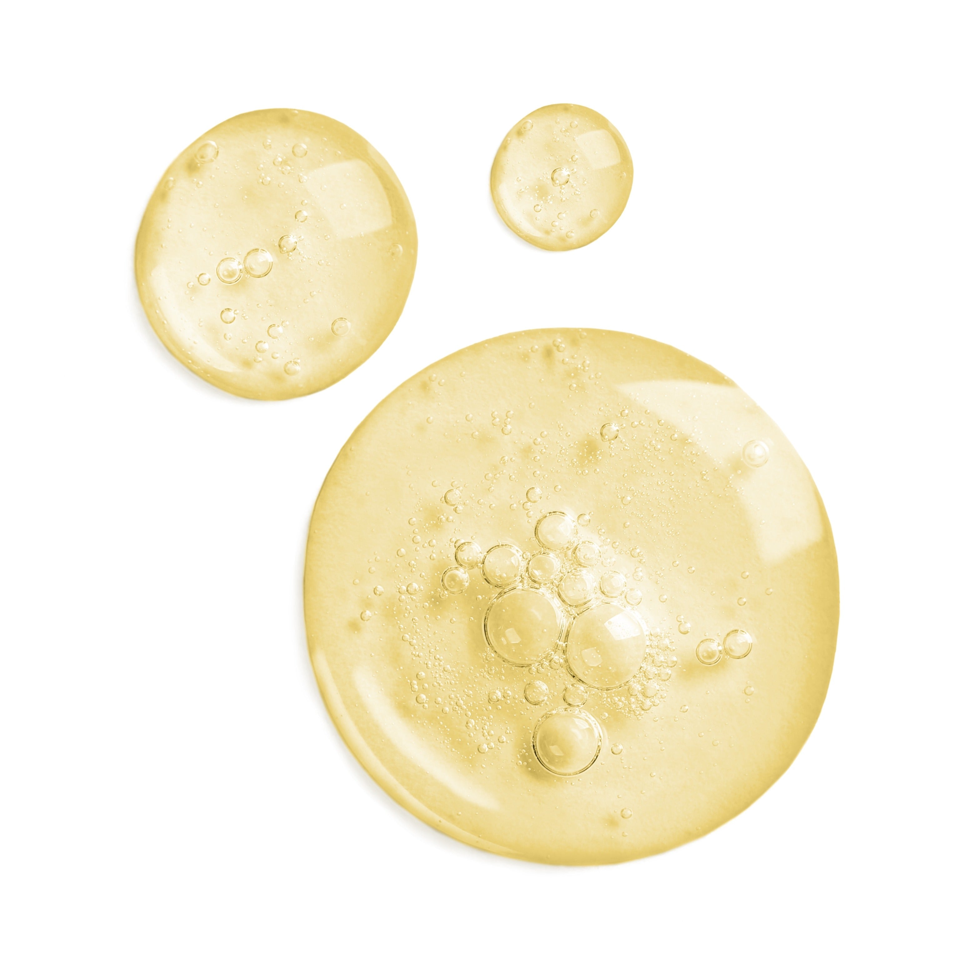 Three droplets of yellow liquid Vitamin E as D-alpha with bubbles on a white background